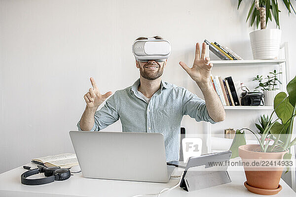 Man wearing VR glasses at desk in office