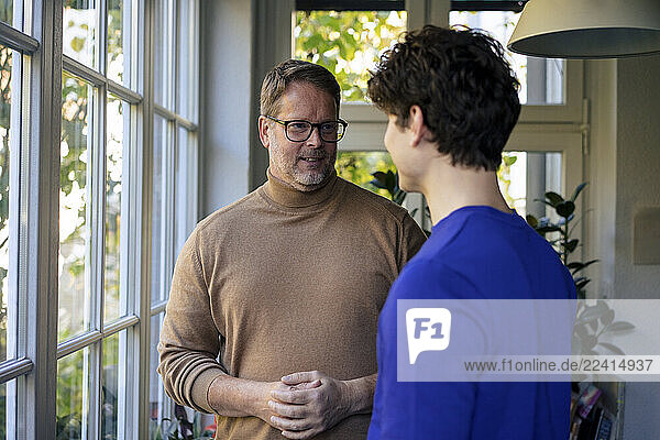 Father giving advice to son at home