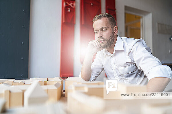Businessman looking at architectural model in office