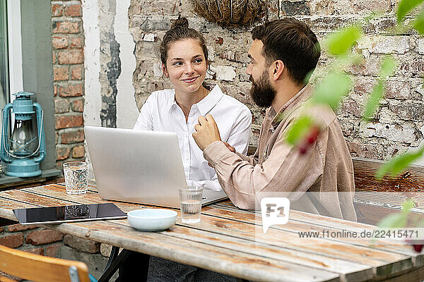 Young couple working in backyard  using laptop