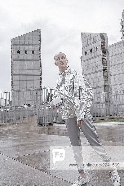 Girl in silver suit carrying VR goggles under her arm
