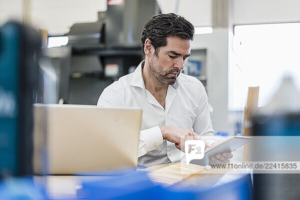 Businessman using tablet in a factory