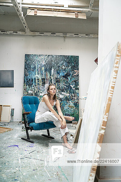 Young artist sitting in her studio