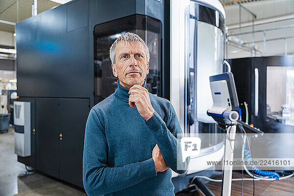 Engineer in a production hall with industrial machinery