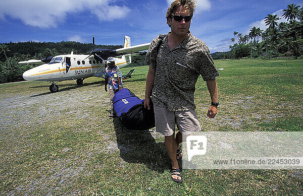 A man carrying his luggage.