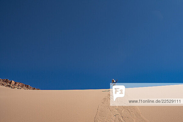 Woman on sand dune in Atacama Desert