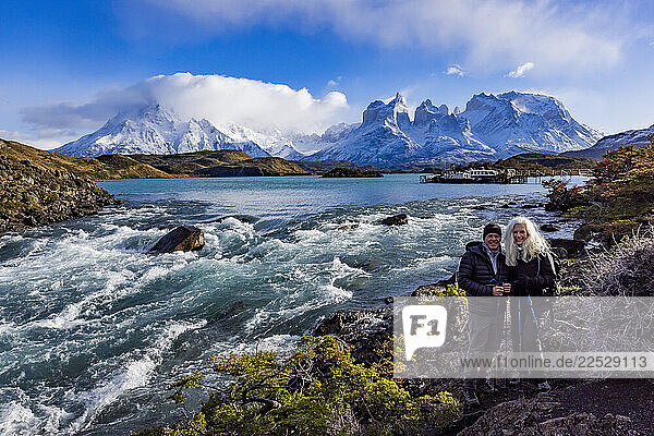 Portrait of couple at Falls at outlet of Lake Pehoe in Torres Del Paine