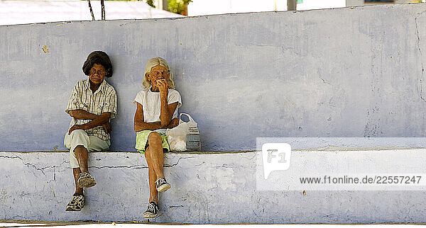 A pair of old ladies catch a midday nap at a bus stop in Bayamo  Cuba.