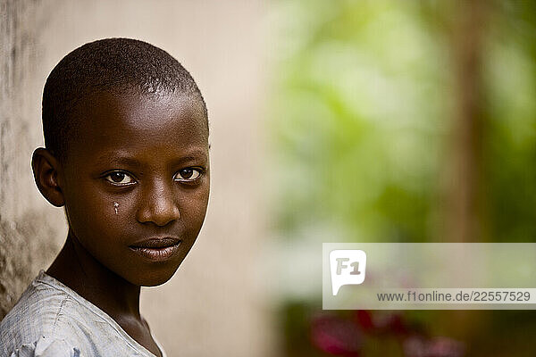 A young Rwandan woman named Kerere in the garden outside her home.