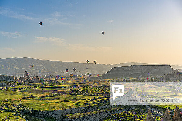 Colorful hot air balloons flying over Capadoccia landscape