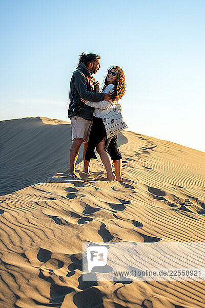 Couple hugging on the sand dunes of Patara beach in Turkey