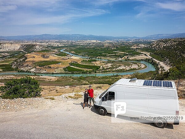 Couple enjoying sustainable travel with camper van