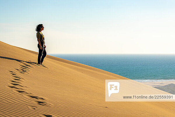 Woman observing the sea from Patara beach sand dunes in Turkey