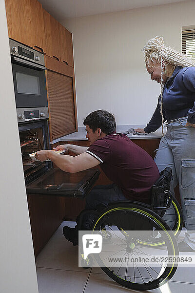 Woman and man in wheelchair baking in kitchen