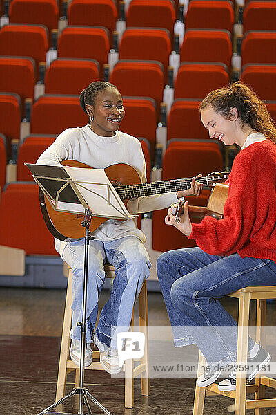 Women with disabilities playing guitars on stage