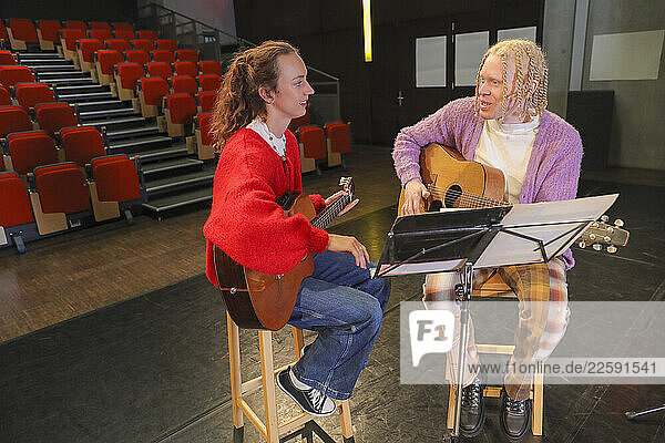 Persons with disabilities playing guitars on stage