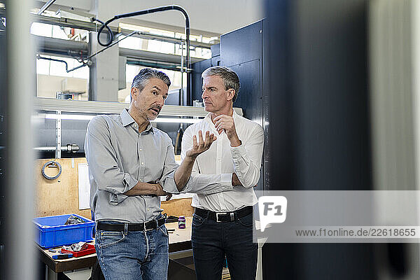 Businessmen in factory  having a meeting  discussing solutions
