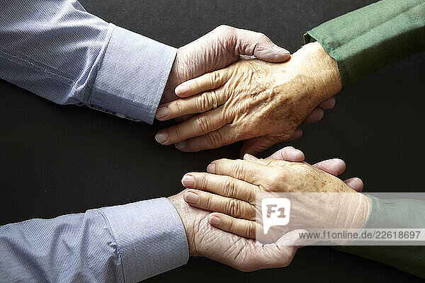Two people holding hands at home symbolizing trust and closeness