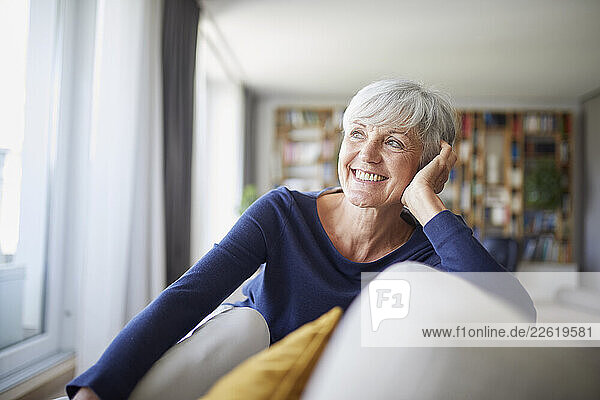 Smiling woman relaxing at home in a cozy living room