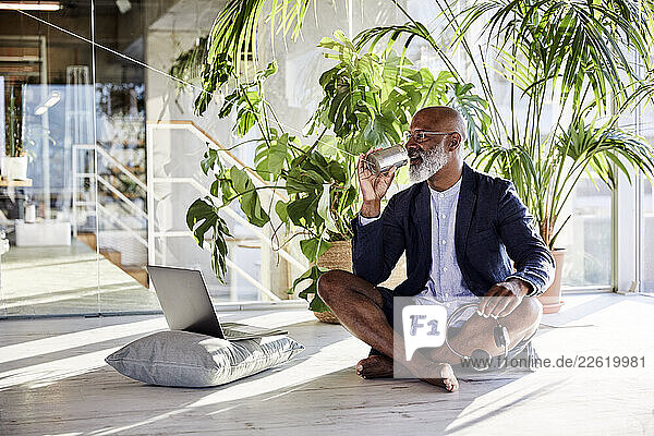 Mature man talking from tin can phone while sitting at home