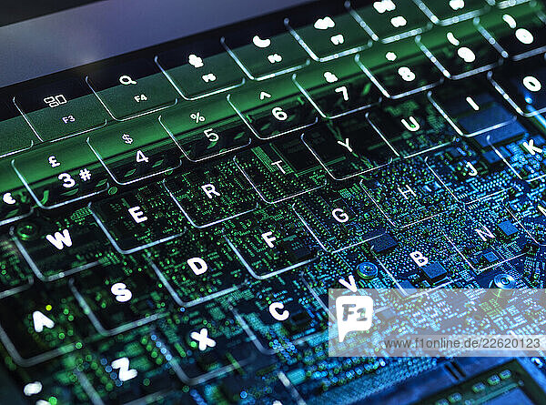 Illuminated laptop keyboard with visible circuit board representing cybersecurity and AI