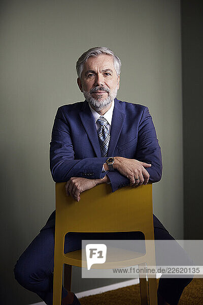 Portrait of confident mature businessman sitting on a chair