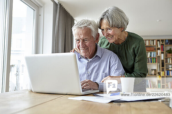 Seniors enjoying time together using a laptop at home