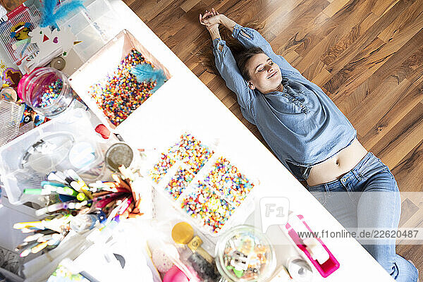 Woman taking a break at home surrounded by art supplies