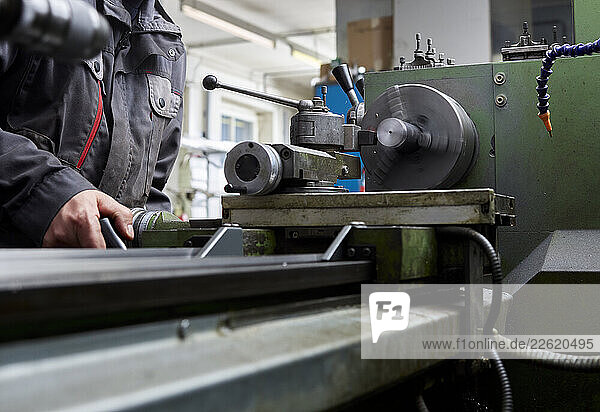 Metal construction technician working at a lathe in a workshop
