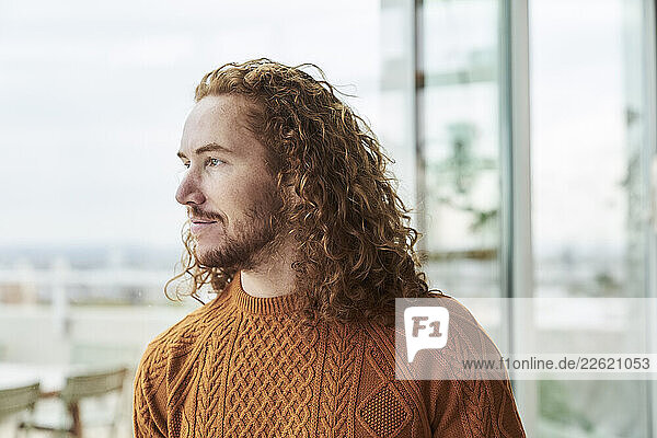 Hipster man looking away on building terrace
