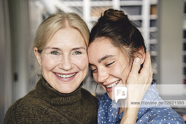 Mother and daughter smiling together at home showing affection and trust
