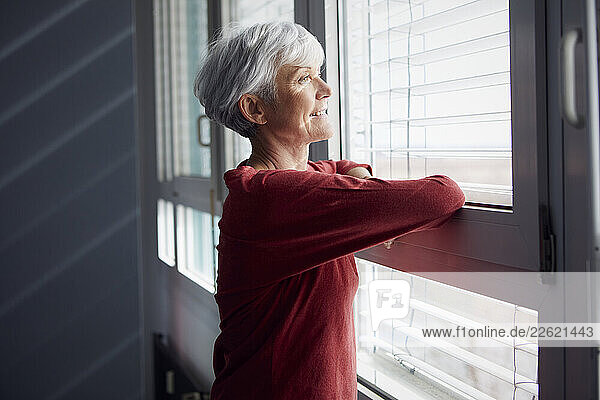 Portrait of senior woman looking out of window