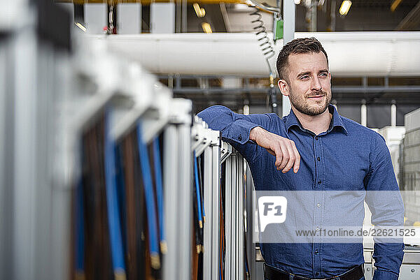 Man in blue shirt standing in an industrial warehouse