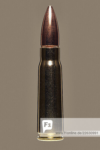 Close up studio shot of 7.62 x 39mm bullet used with AK-47 on brown background