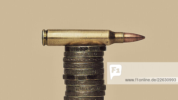 UK Defense Spending- still life of bullet cartridge on stack of British Pound coins
