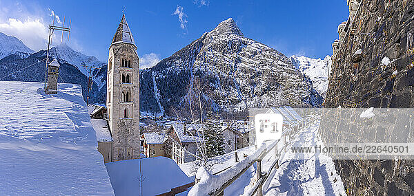 View of snow covered mountains  rooftops and Church of Saint Pantalon in Courmayeur in winter  Courmayeur  Aosta Valley  Italian Alps  Italy