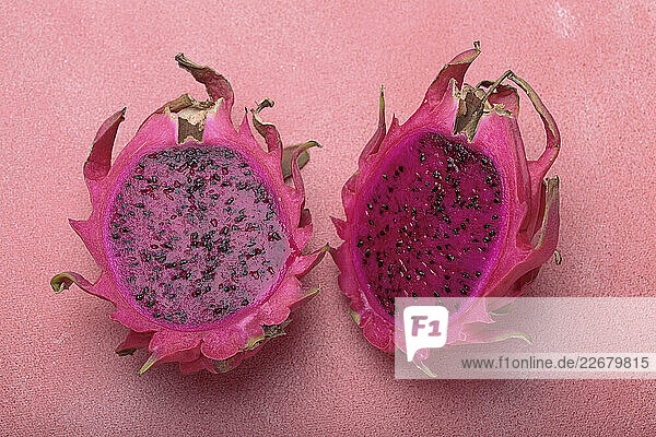 Aufgeschnittene Drachenfrucht auf rosa Hintergrund