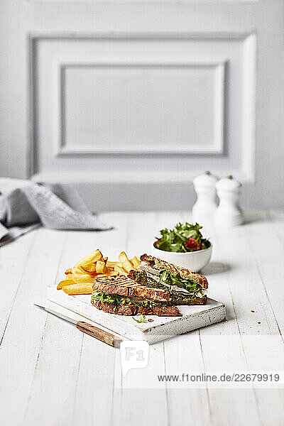 Hähnchen-Avocado-Sandwich mit Pommes und Salat