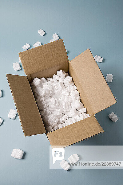 Open cardboard box filled with packing foam peanuts made of expanded polystyrene