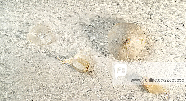 Pealed garlic on rough white board