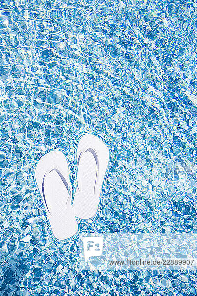 Flip Flops floating on swimming pool water surface