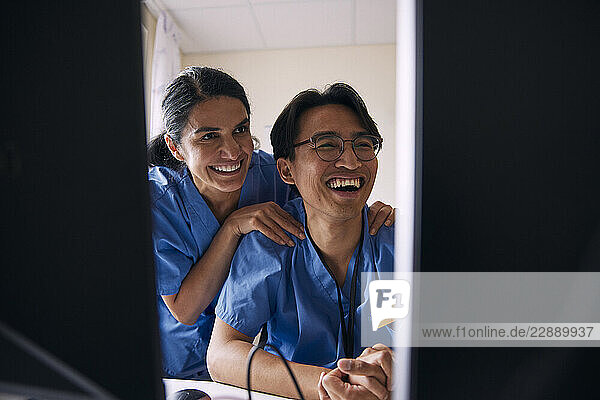 Happy doctors discussing over video call in clinic