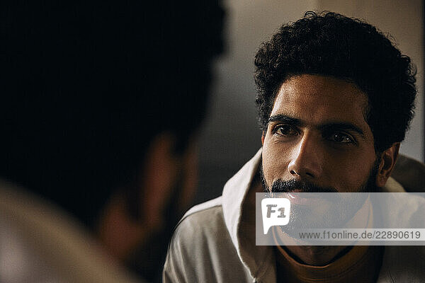 Close-up of bearded man looking in mirror