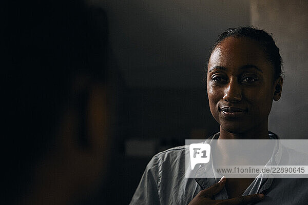 Reflection of woman in mirror at bathroom