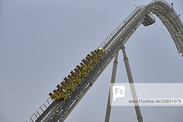A group of people on a steep roller coaster incline against a clear blue sky. Abu Dhabi  UAE