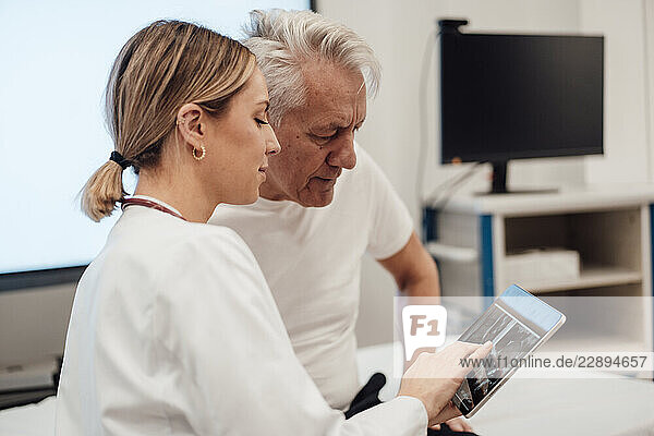 Doctor consulting with patient using a tablet in a medical office