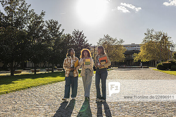 Teacher and students discussing on a university campus in sunlight