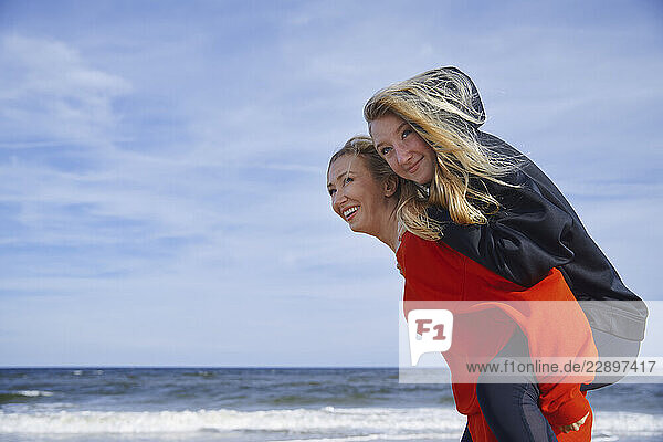 Mother and daughter enjoying a fun day at the beach by the ocean
