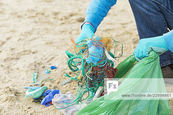 Man collecting ocean waste during a beach cleanup on the North Sea