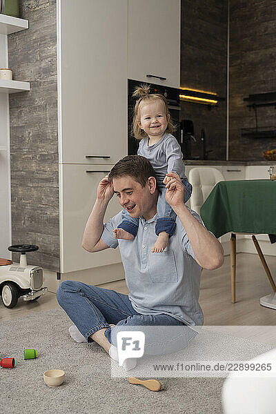 Father and daughter playing together at home in the kitchen
